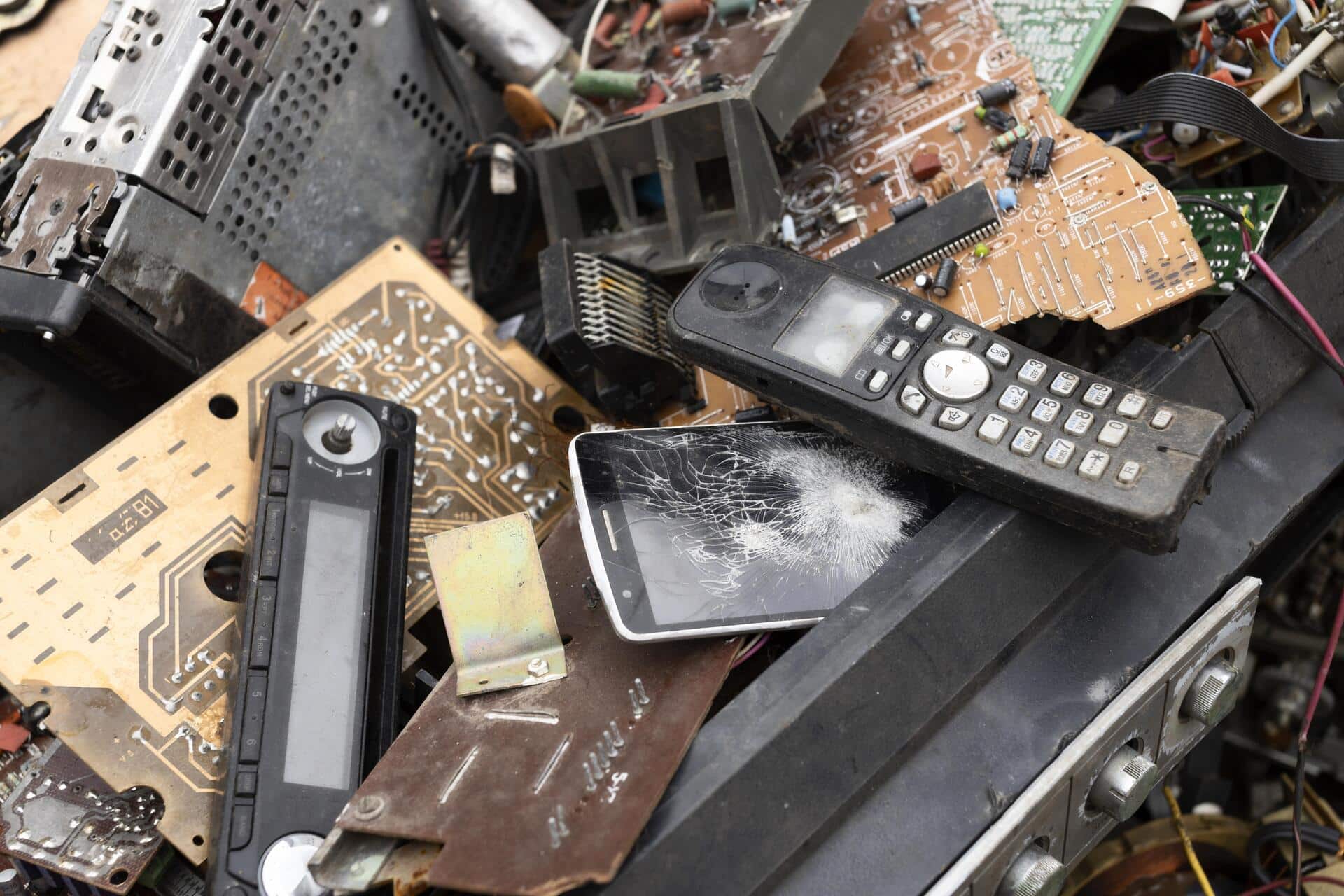 Foto de equipamentos eletroeletrônicos, como celulares, telefones e placas de computadores, que chegaram ao fim da vida útil e se tornaram lixo eletrônico